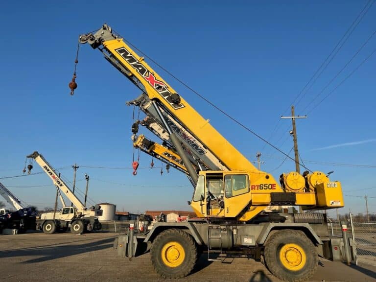 A used crane for sale sitting in a lot with other used cranes