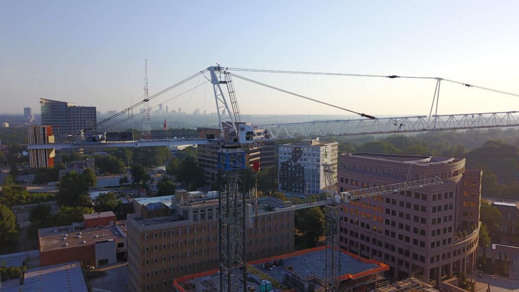 Closeup of a tower crane as the sun is setting on a building project.