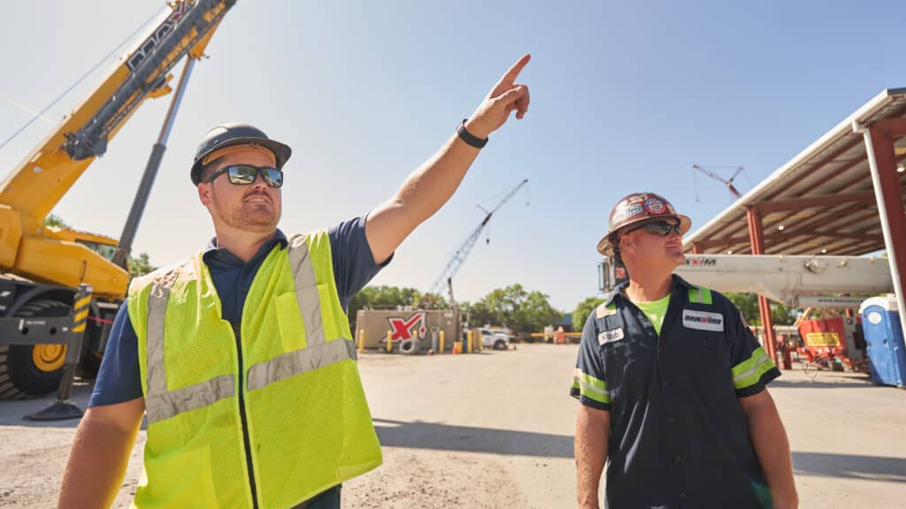 Maxim crew giving hand signals to a crane operator